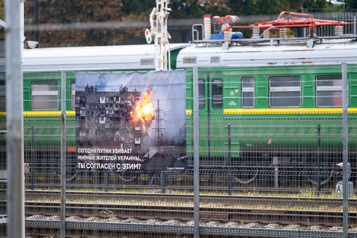 Eins von mehreren Plakaten zeigt ein Bild aus dem Ukraine-Krieg auf dem Bahnsteig von Vilnius, auf dem zweimal täglich ein russischer Zug von Moskau in die russische Enklave Kaliningrad hält. Die Bild ...