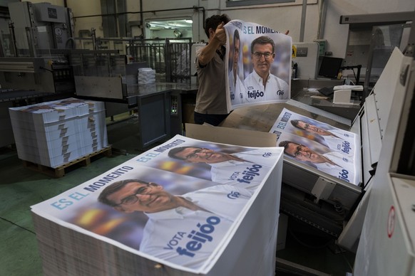 A print house staffer works on election campaign posters of Popular Party candidate Nunez Feijoo in Madrid, Spain, Friday, June 30, 2023. Spain&#039;s elections Sunday will be a battle between two lef ...