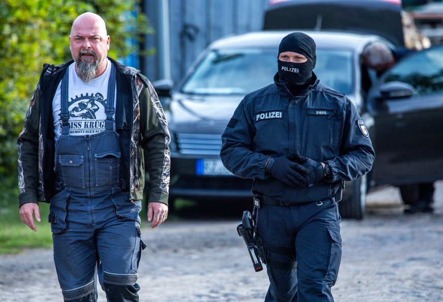 19.09.2023, Mecklenburg-Vorpommern, Jamel: Sven Krüger (l), bundesweit bekannter Rechtsextremist, wird bei einer Durchsuchungsaktion auf seinem Grundstück von einem Polizeibeamten begleitet. Bundesinn ...