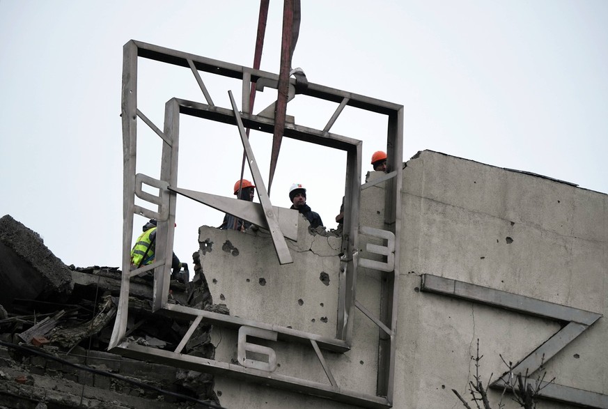 Russia DPR Construction 8616482 10.02.2024 Workers dismantle the clock on the building of the Main Post Office, better known as the House of Communications, damaged in the course of Russia s military  ...