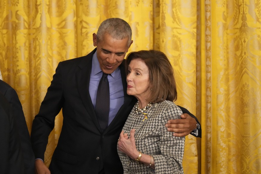 Former United States President Barack Obama hugs Speaker of the US House of Representatives Nancy Pelosi Democrat of California as US President Joe Biden signs an executive order mandating a rule chan ...