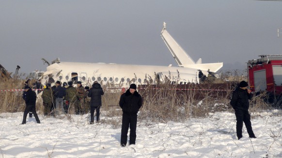 27.12.2019, Kasachstan, Almaty: Polizisten stehen am Ort eines Flugzeugabsturzes. Beim Absturz eines Passagierjets der kasachischen Fluggesellschaft Bek Air unmittelbar nach dem Start in Almaty sind m ...