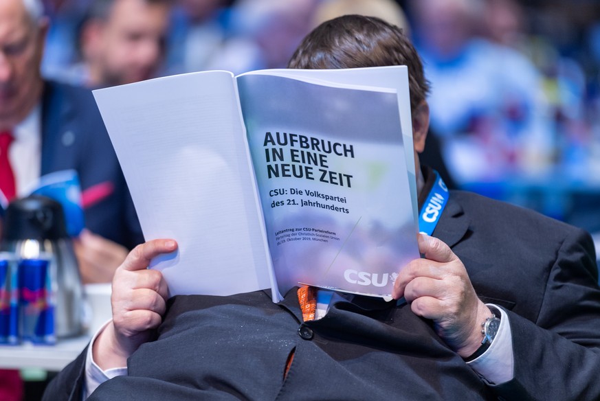 Ein CSU-Mitglied liest beim Abschluss des CSU-Parteitags in der Olympiahalle in einem CSU-Heft mit der Aufschrift "Aufbruch in eine neue Zeit".