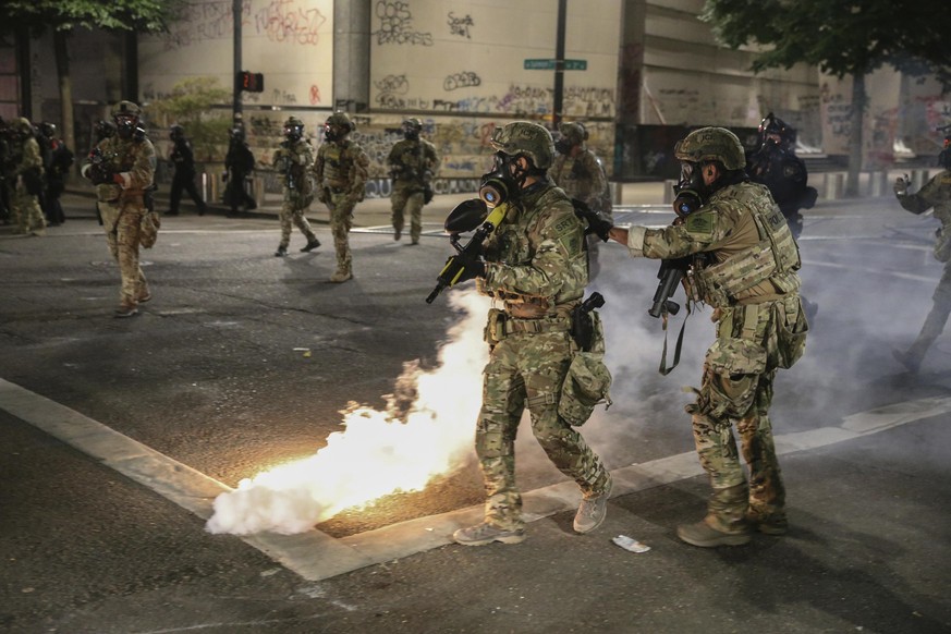 18.07.2020, USA, Portland: Die Polizei reagiert während einer Protestaktion auf Demonstranten. Die von US-Präsident Donald Trumps Regierung entsandten militarisierten Sicherheitskräfte waren dort gege ...