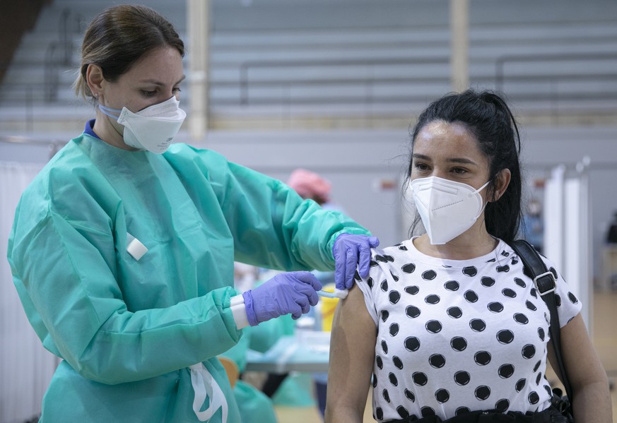 18.02.2021, Spanien, Seville (andalusia): Einer Frau mit Maske wird in den Sportanlagen des Sadus-Pavillons der Universit