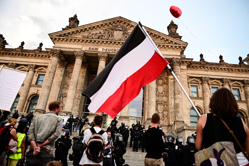 Kundgebung gegen die Corona-Maßnahmen vor dem Reichstag, ein Teilnehmer hält eine Reichsflagge. Der Verfassungsschutz hat an diesem Dienstag seinen Jahresbericht für 2021 veröffentlicht.