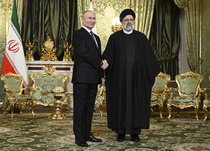 07.12.2023, Russland, Moskau: Auf diesem von der staatlichen russischen Nachrichtenagentur Sputnik via AP veröffentlichten Foto gibt Wladimir Putin (l), Präsident von Russland, Ebrahim Raisi, Präsiden ...