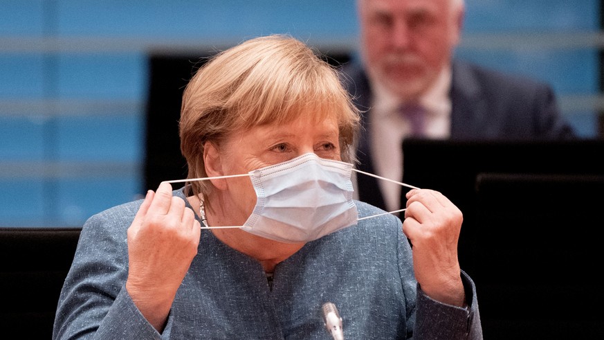 German Chancellor Angela Merkel removes her face mask before the National Integration Prize honoring engagement for integration in Berlin, October 5, 2020. Kay Nietfeld/Pool via REUTERS