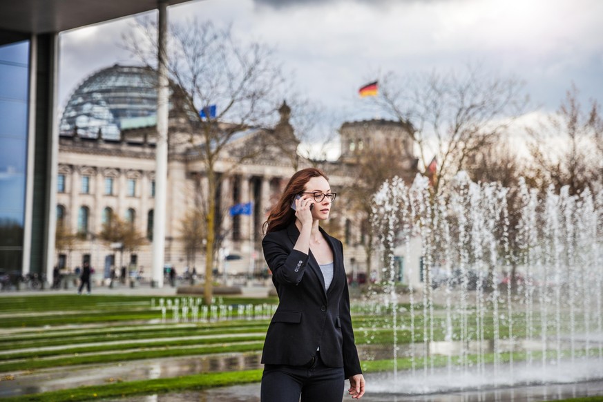 Woman in business outside the office building in downtown waiting for a meeting.