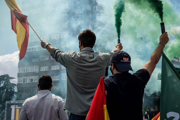 May 1, 2021, Madrid, Spain: Supporters hold burning flares with the green color of VOX in the Plaza Conde de Casal..Within the framework of May 1, International Labor Day, the Spanish far-right party  ...