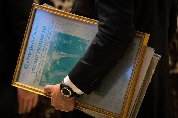 NEW YORK, NY - NOVEMBER 22: A staff member with the transition team carries a printing press plate of the November 9th edition of The New York Times at Trump Tower, November 22, 2016 in New York City. ...
