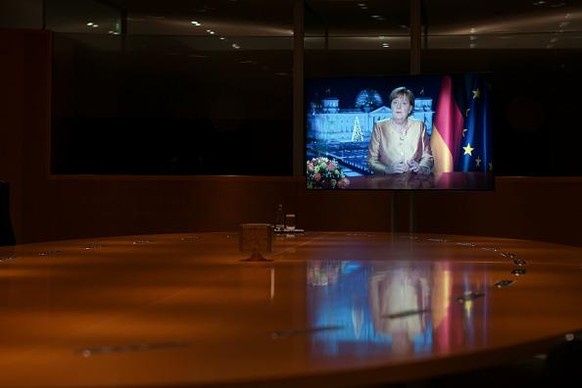 BERLIN, GERMANY - DECEMBER 30: (EMBARGOED FOR PUBLICATION until 00:00 CET on December 31, 2020) German Chancellor Angela Merkel is displayed on a screen during the television recording of her annual N ...
