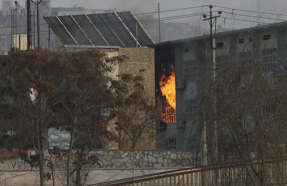 Flames rise from a government building after an explosion and attack by gunmen, in Kabul, Afghanistan, Monday, Dec. 24, 2018. (AP Photo/Rahmat Gul)