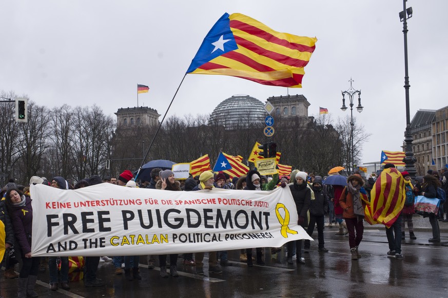 People with a banner lead a protest in front of the Reichstag building, condemning the arrest of Catalonia&#039;s former president, Carles Puigdemont in Germany, at a demonstration in Berlin, Germany, ...