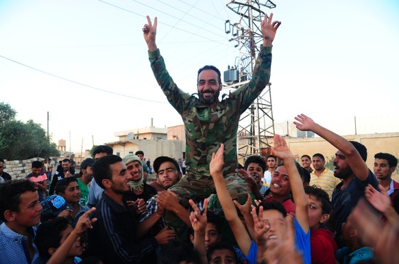 (180709) -- DARAA, July 9, 2018 () -- People carry a Syrian soldier as they welcome Syrian army in the Kharab al-Shahem town in the western countryside of Daraa province in southern Syria on July 8, 2 ...