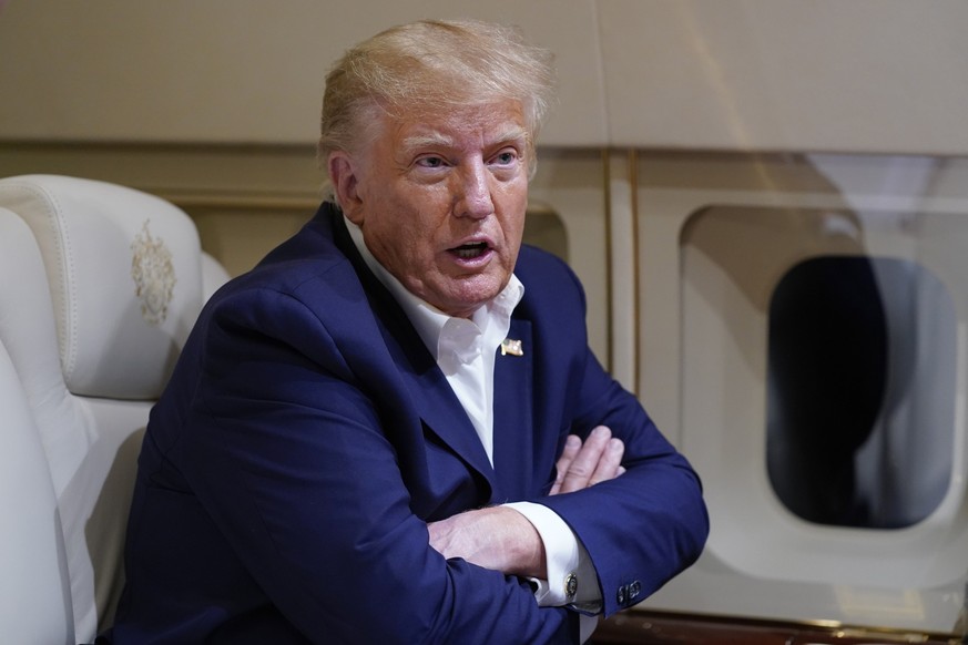 FILE - Former President Donald Trump speaks with reporters while in flight on his plane after a campaign rally at Waco Regional Airport, in Waco, Texas, March 25, 2023, while en route to West Palm Bea ...