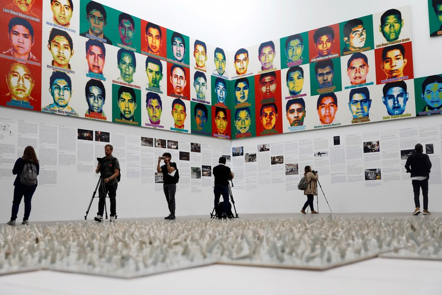 Journalists are seen in front of portraits of the 43 missing Ayotzinapa College Raul Isidro Burgos students during a press preview of the exhibition &quot;Restablecer Memorias&quot; by Chinese artist  ...