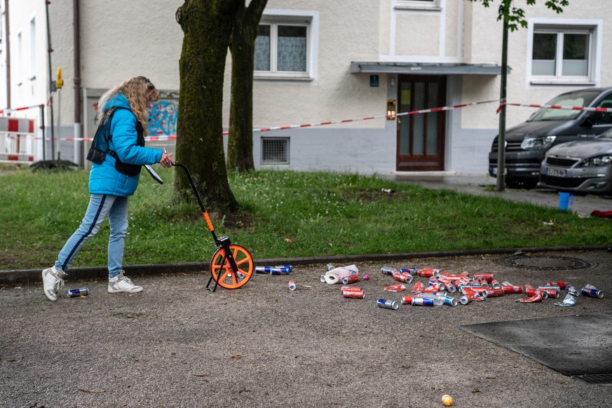 Eine Frau von der Spurensicherung vermisst die Stelle, an der ein Fahrzeug in eine Gruppe von Menschen gefahren ist.