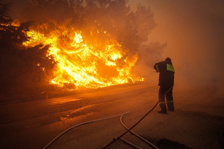 Ein Feuerwehrmann kämpft in der Nähe von Athen gegen die Flammen der verheerenden Waldbrände.