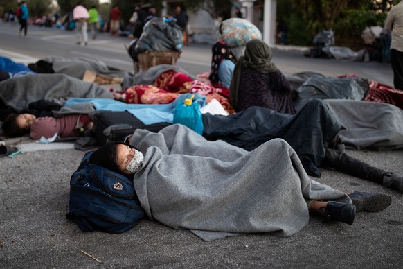 Refugees and migrants sleep on a road following a fire at the Moria camp on the island of Lesbos, Greece, September 10, 2020. REUTERS/Alkis Konstantinidis