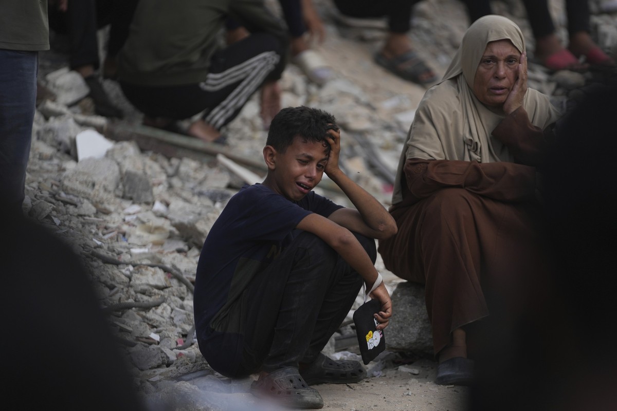 26.07.2025, Palästinensische Gebiete, Gaza-Stadt: Palästinenser beten im Schifa-Krankenhaus in Gaza-Stadt an der Leiche eines Menschen, der bei dem Versuch getötet wurde, Hilfsgütertransporter zu erre ...