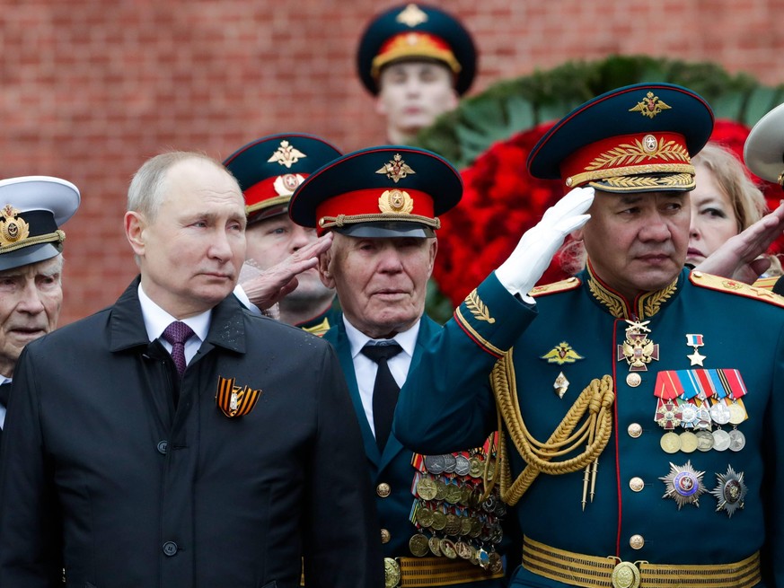 MOSCOW, RUSSIA MAY 9, 2021: Russia s President Vladimir Putin and Defence Minister Sergei Shoigu L-R front attend a flower laying ceremony at the Tomb of the Unknown Soldier by the Kremlin Wall to mar ...