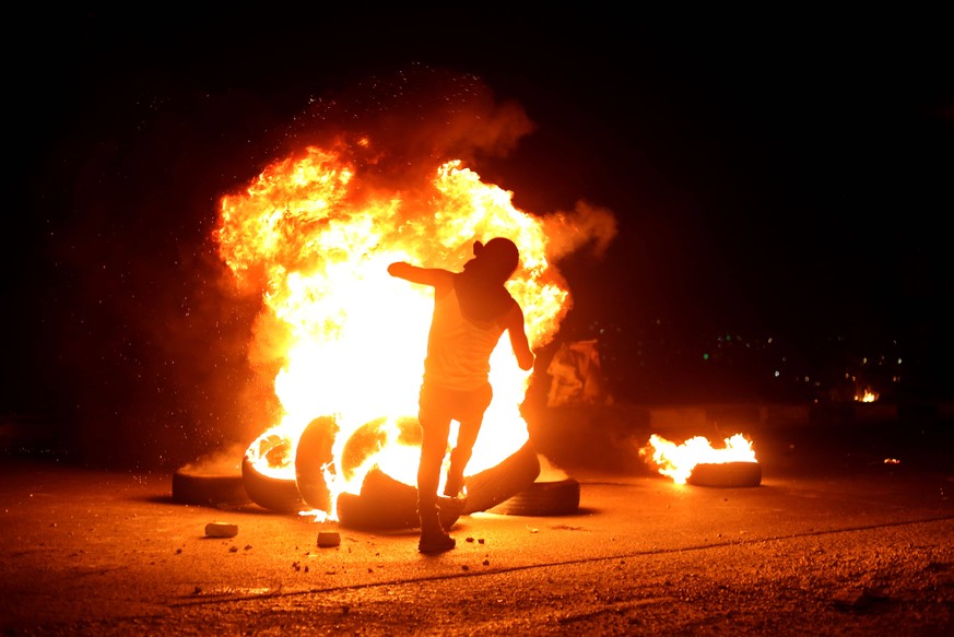 210510 -- NABLUS, May 10, 2021 -- A protester burns tires during clashes with Israeli soldiers at Huwwara checkpoint near the West Bank city of Nablus, on May 10, 2021. Tension between Israelis and Pa ...