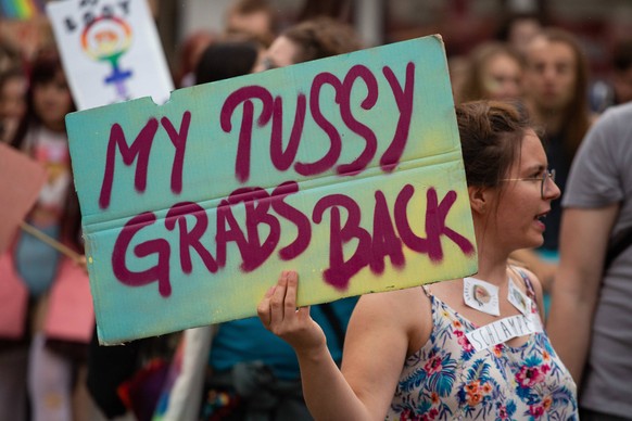 July 21, 2018 - Munich, Bavaria, Germany - Protestor holds sign saying My pussy grabs back referring to Donald Trump. Some 500 people demonstrated through the streets of Munich to protest against sexi ...