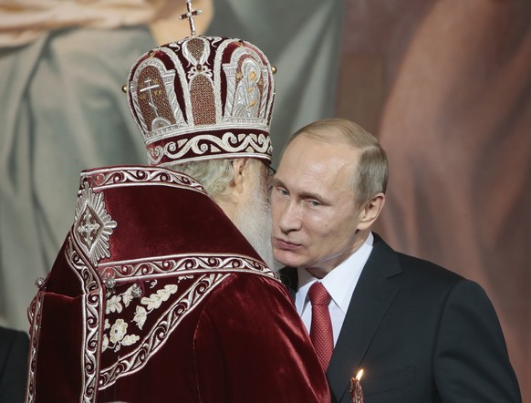 MOSCOW, RUSSIA. APRIL 12, 2015. Patriarch Kirill of Moscow and all Russia (L) and the president of Russia, Vladimir Putin, greet each other at an Orthodox Easter liturgy at the Cathedral of Christ the ...