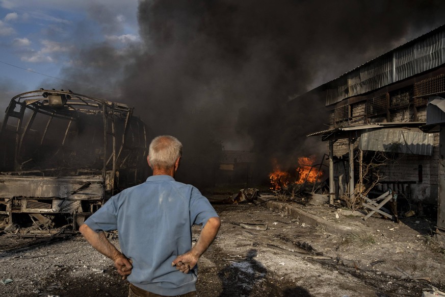 Ein Ukrainer steht vor den Trümmern einer Garage in Lyssytschansk. Er sieht zu, wie sein Auto verbrennt.