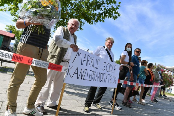 Passanten mit Banner SOEDER KANZLERKANDIDAT 2021 JA. Bayerisches Kabinett tagt gemeinsam mit Bundeskanzlerin Merkel auf Schloss Herrenchiemsee am 14.07.2020. *** Passers-by with banner SOEDER KANZLERK ...