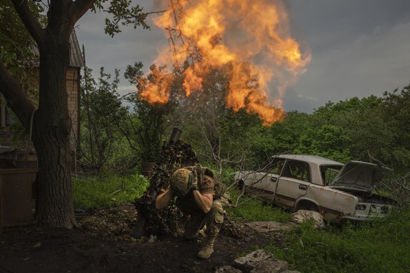 A Ukrainian soldier fires a mortar at Russian positions on the front line near Bakhmut, Ukraine, Sunday, May 28, 2023. (AP Photo/Efrem Lukatsky)