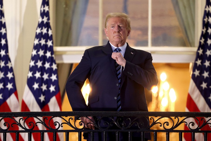 WASHINGTON, DC - OCTOBER 05: U.S. President Donald Trump gestures on the Truman Balcony after returning to the White House from Walter Reed National Military Medical Center on October 05, 2020 in Wash ...