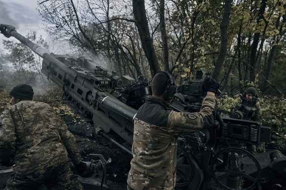 23.10.2022, Ukraine, Donezk: Ukrainische Soldaten feuern aus einer von den USA gelieferten Haubitze M777. Foto: Libkos/AP/dpa +++ dpa-Bildfunk +++
