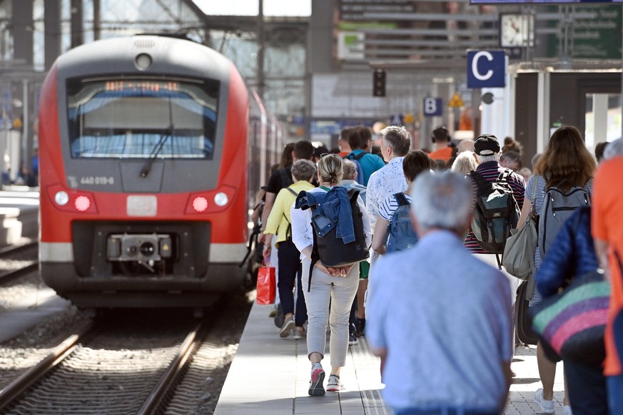 Menschen laufen auf einem vollem Gleis am Münchner Hauptbahnhof zum Zug.