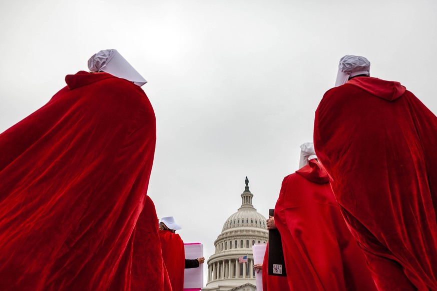 Handmaids Army DC protest Supreme Courts preliminary decision to overturn Roe v. Wade Demonstrators dressed as handmaids from The Handmaid s Tale, walk to the Capitol during a protest by the Handmaids ...