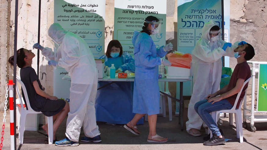 200703 -- LOD, July 3, 2020 Xinhua -- Medical workers take samples from citizens for COVID-19 test in the central Israeli city of Lod on July 2, 2020. The number of active coronavirus cases in Israel  ...