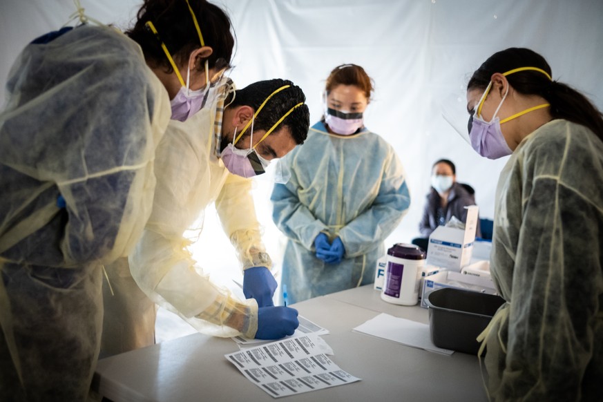 NEW YORK, NY - MARCH 24: Doctors test hospital staff with flu-like symptoms for coronavirus (COVID-19) in set-up tents to triage possible COVID-19 patients outside before they enter the main Emergency ...