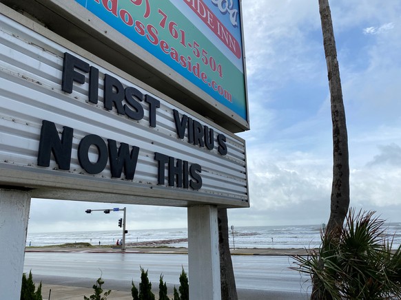 A sign referencing the coronavirus disease (COVID-19) and Hurricane Laura is seen in Galveston, Texas, U.S., August 26, 2020. REUTERS/Julio-Cesar Chavez