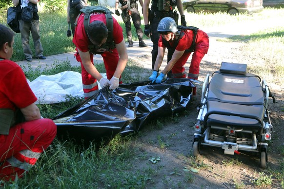 KHARKIV, UKRAINE - JUNE 27, 2022 - Paramedics bag the body of a man who died as a result of rocket attacks by the russian troops on a residential area of Kharkiv, northern Ukraine. This photo cannot b ...