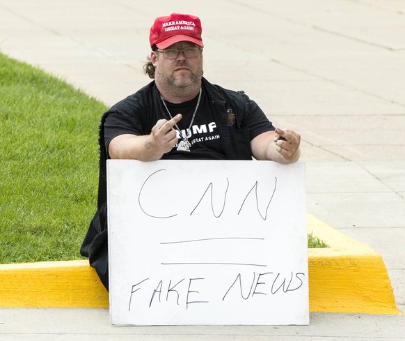 July 31, 2019, Detroit, Michigan, USA: A Trump supporter uses sign language to communicate with the photographer at the second of two Democratic Debates in Detroit hosted by CNN and sanctioned by the ...