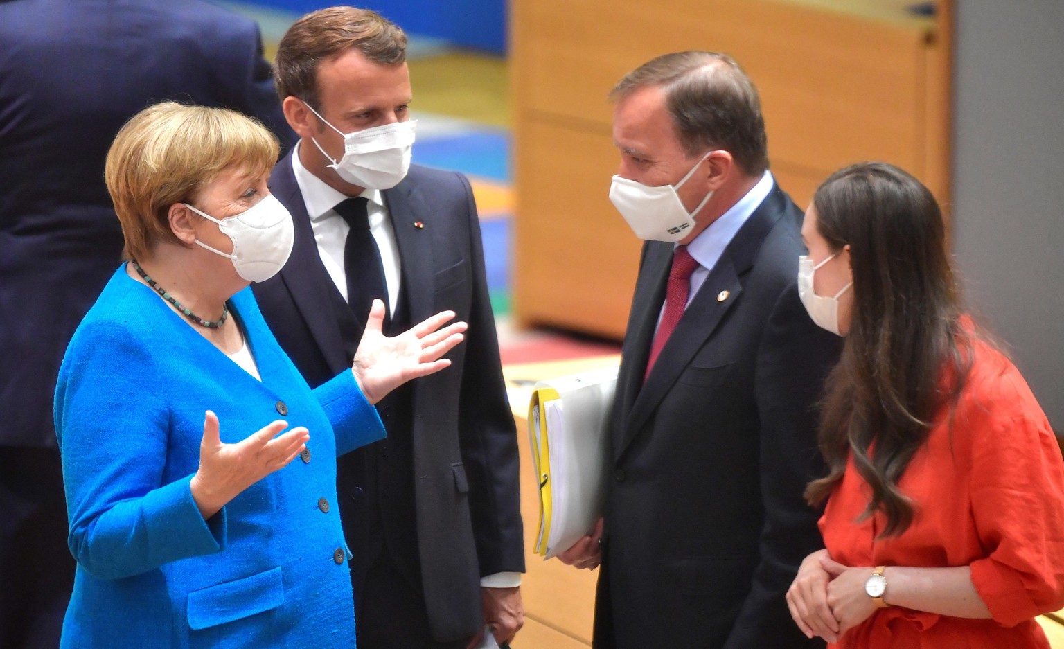 German Chancellor Angela Merkel, left, and French President Emmanuel Macron, second left, speak with Sweden's Prime Minister Stefan Lofven, second right, and Finland's Prime Minister Sanna Marin, righ ...