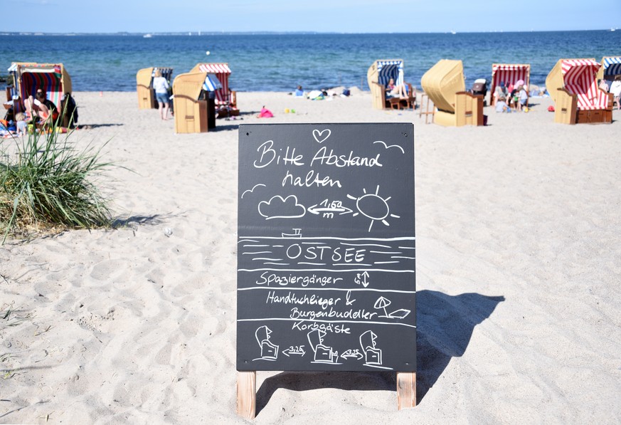 dpatopbilder - 21.05.2020, Schleswig-Holstein, Niendorf: Ein Schild mit der Aufschrift &quot;Bitte Abstand halten&quot; steht am Zugang zum Strand an der Ostsee. Foto: Daniel Bockwoldt/dpa +++ dpa-Bil ...