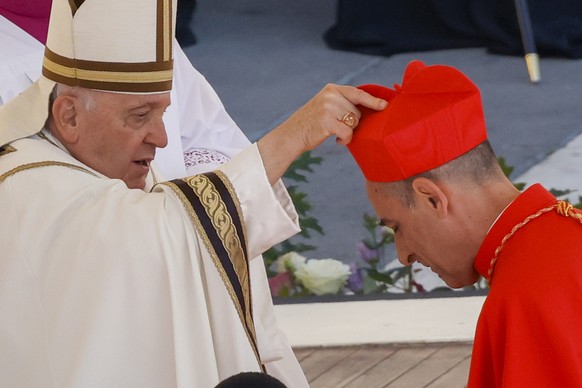 Newly elected Cardinal Víctor Manuel Fernández, Prefect of the Dicastery for the Doctrine of the Faith, right, receives his biretta from Pope Francis as he is elevated in St. Peter&#039;s Square at Th ...