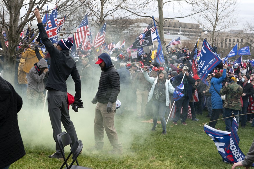 FILE - In this Jan. 6, 2021, file photo, supporter of President Donald Trump protest as U.S. Capitol Police officers shoot tear gas at demonstrators outside of the U.S. Capitol in Washington. Far-righ ...