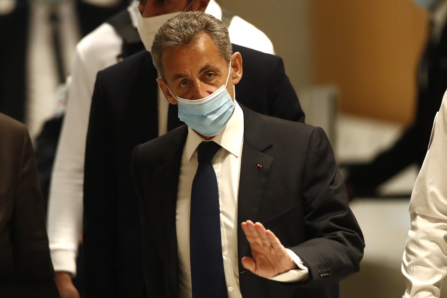 Former French President Nicolas Sarkozy arrives at the courtroom Monday, March 1, 2021 in Paris. The verdict is expected in a landmark corruption and influence-peddling trial that has put French forme ...