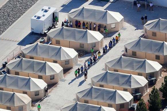 FILE PHOTO: Immigrant children now housed in a tent encampment under the new &quot;zero tolerance&quot; policy by the Trump administration are shown walking in single file at the facility near the Mex ...