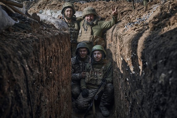 24.03.2023, Ukraine, Bachmut: Ukrainische Soldaten der 28. Brigade posieren für ein Foto in einem Graben an der Frontlinie in der Näche von Bachmut während der Kämpfe gegen russischen Truppen. Foto: L ...