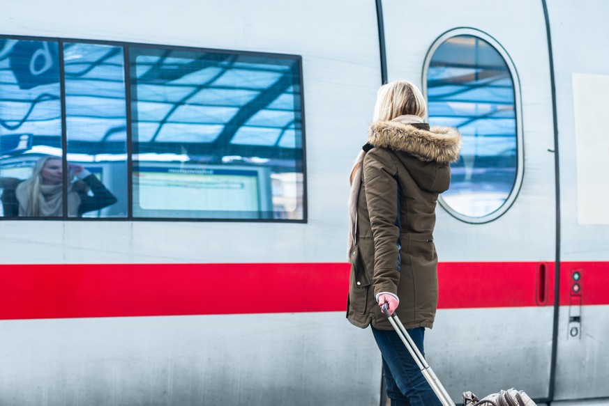 Woman waiting for her train with luggage in station ready to travel