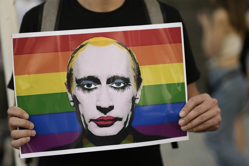 A person holds a rainbow colored poster featuring an image depicting Russia&#039;s President Vladimir Putin in downtown Buenos Aires, Argentina, Saturday, Nov. 4, 2023, where thousands have gathered t ...